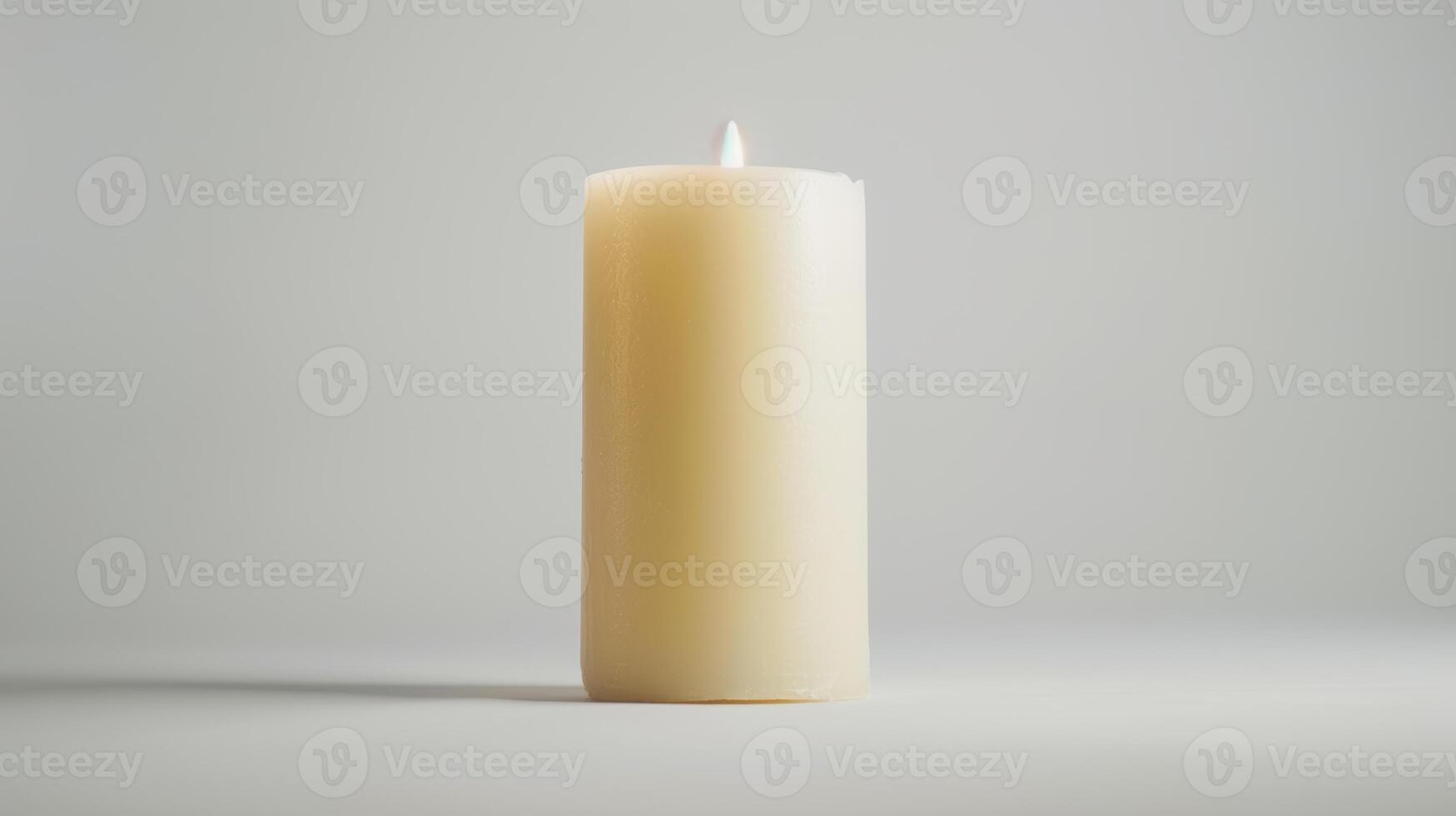Solitary white candle illuminates a white backdrop, creating a simple and minimalist look photo