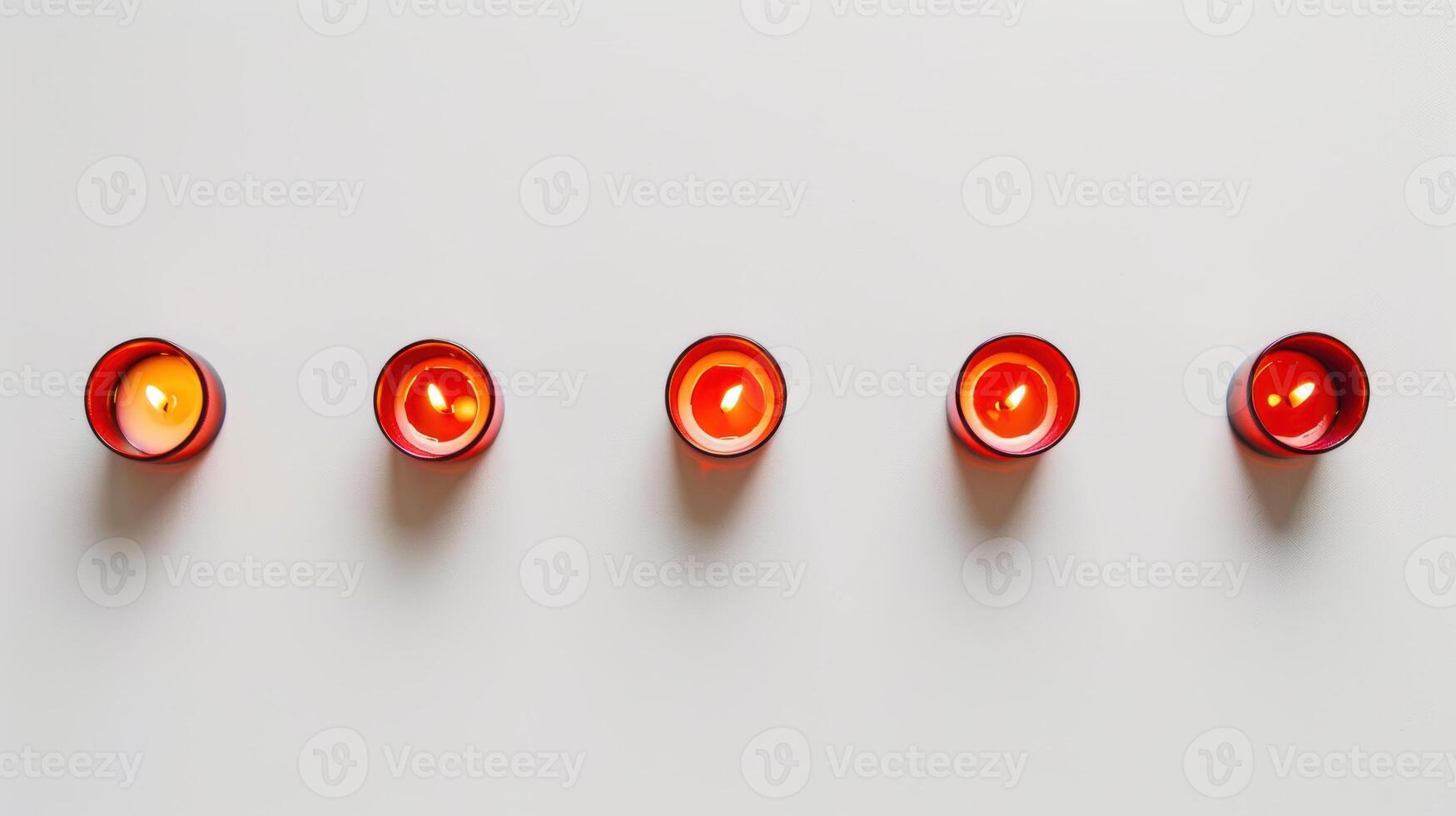Five red aromatic candles burning with yellow flame on white background creating cozy atmosphere photo