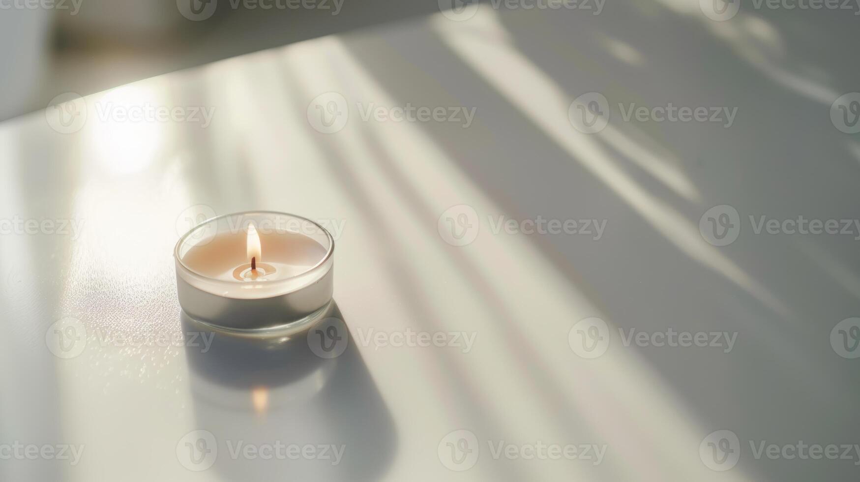 Scented candle casting a calming ambiance on a white table with window shadows photo