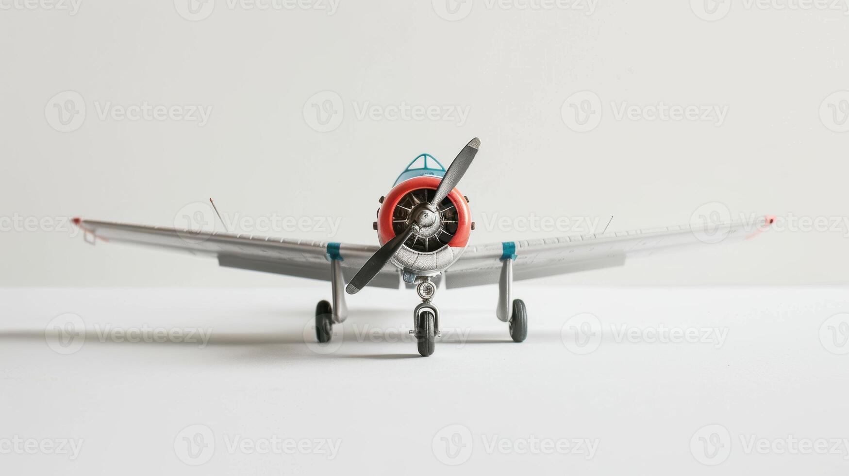 Toy airplane in blue and red on a white surface with a white background photo