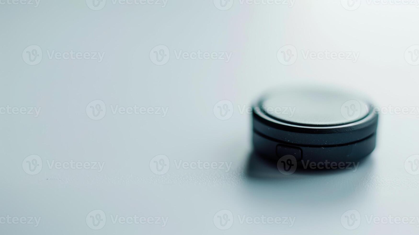 Tiny black gps tracker rests on a white background, poised to offer location data photo