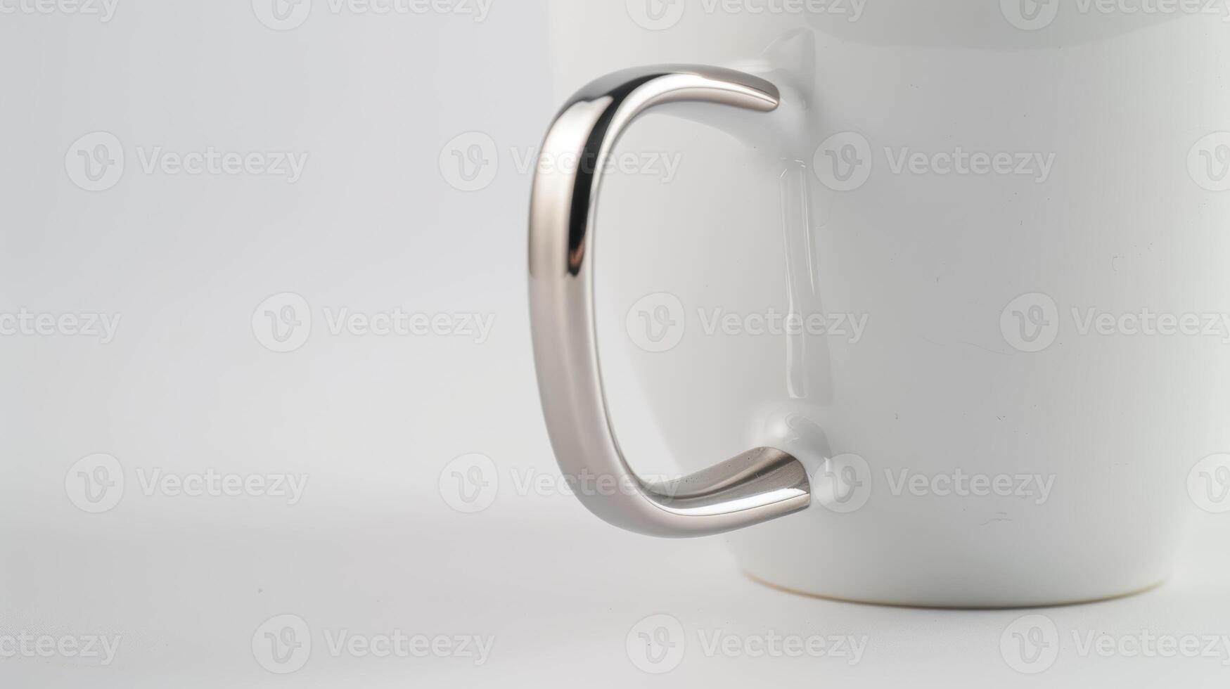 Shiny metallic handle on a white mug against a white background photo
