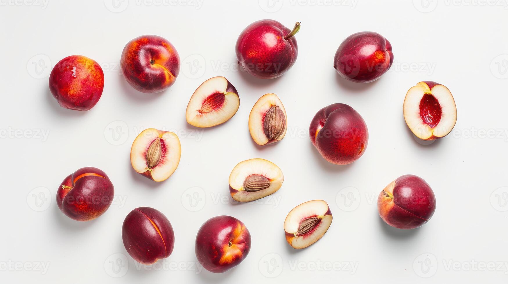 Ripe nectarines, some cut in half showing the stone, lying on a white background photo