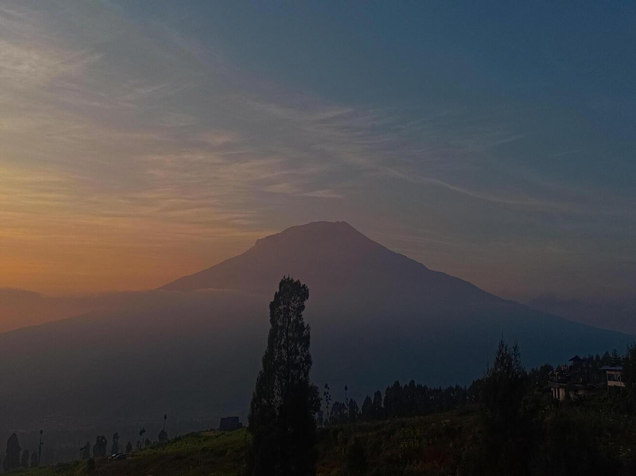 Majestic Misty Mountain at Sunrise with Serene Countryside and Horizon photo