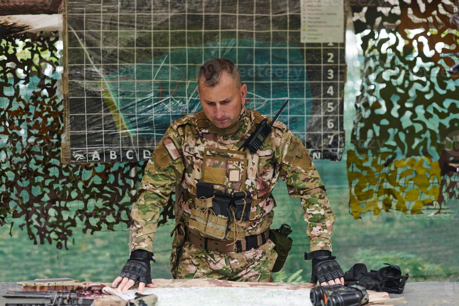 The esteemed leader of an elite military unit, strategic brilliance unfolds as he meticulously devises tactical plans for the upcoming military operation, surrounded by cutting-edge technology and a photo