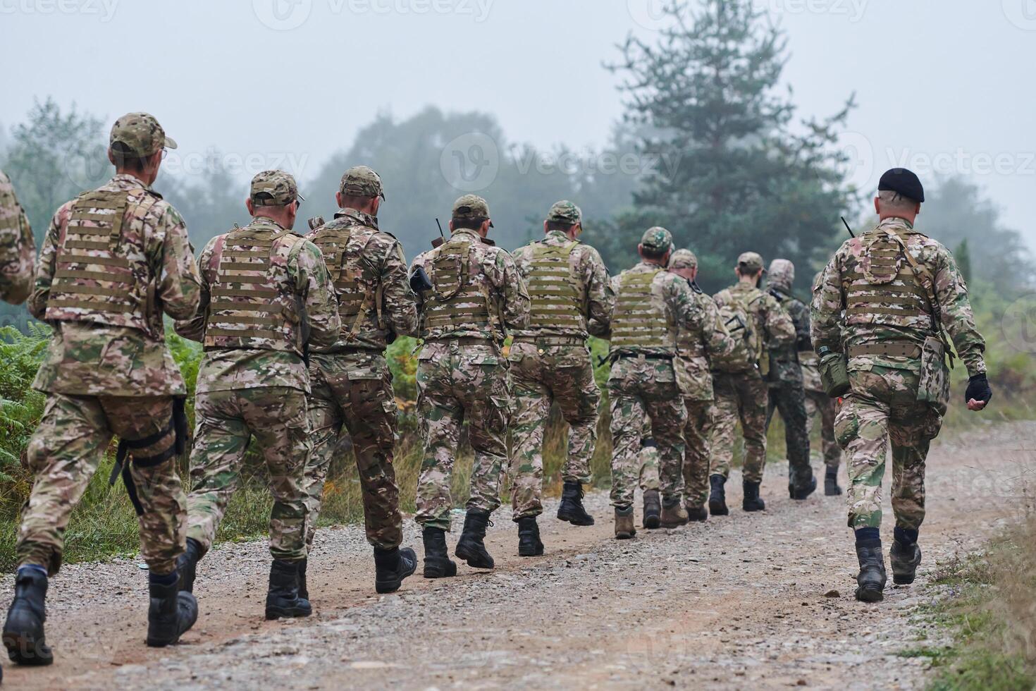 An elite military unit, led by a major, confidently parades through dense forest, showcasing precision, discipline, and readiness for high-risk operations photo