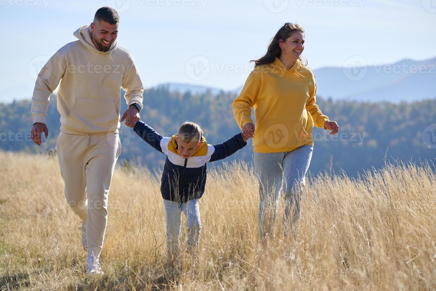 A modern family, along with their son, revels in the joy of a muddy day in nature, running and playing together, encapsulating the beauty of a healthy and active lifestyle photo