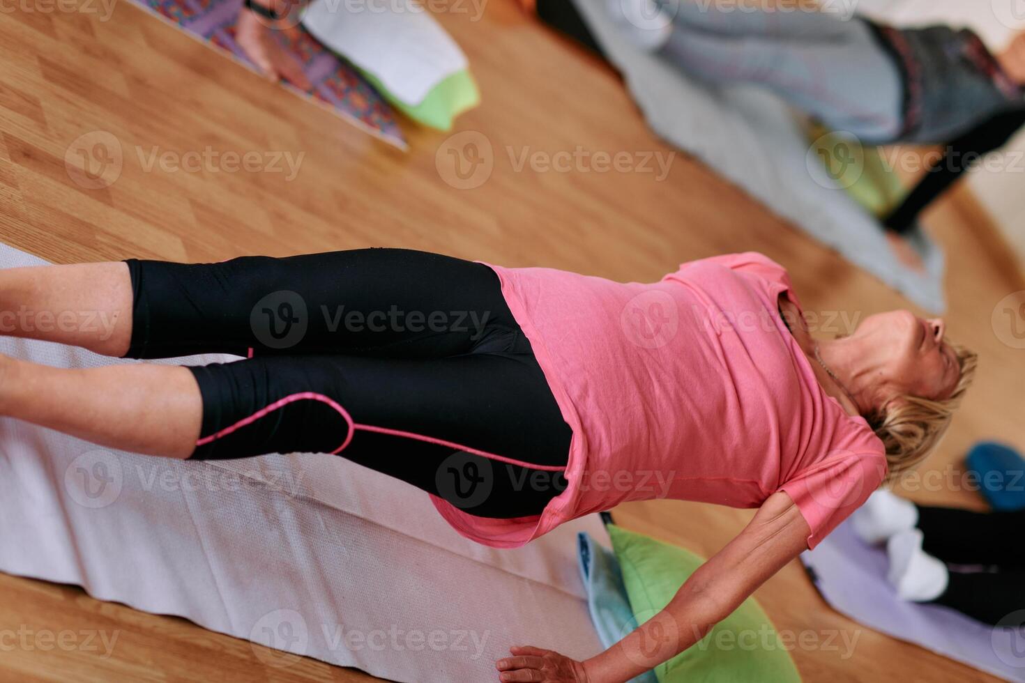 Senior Woman Practicing Back Stretches in a Sunlit Space for Optimal Health and Well Being photo