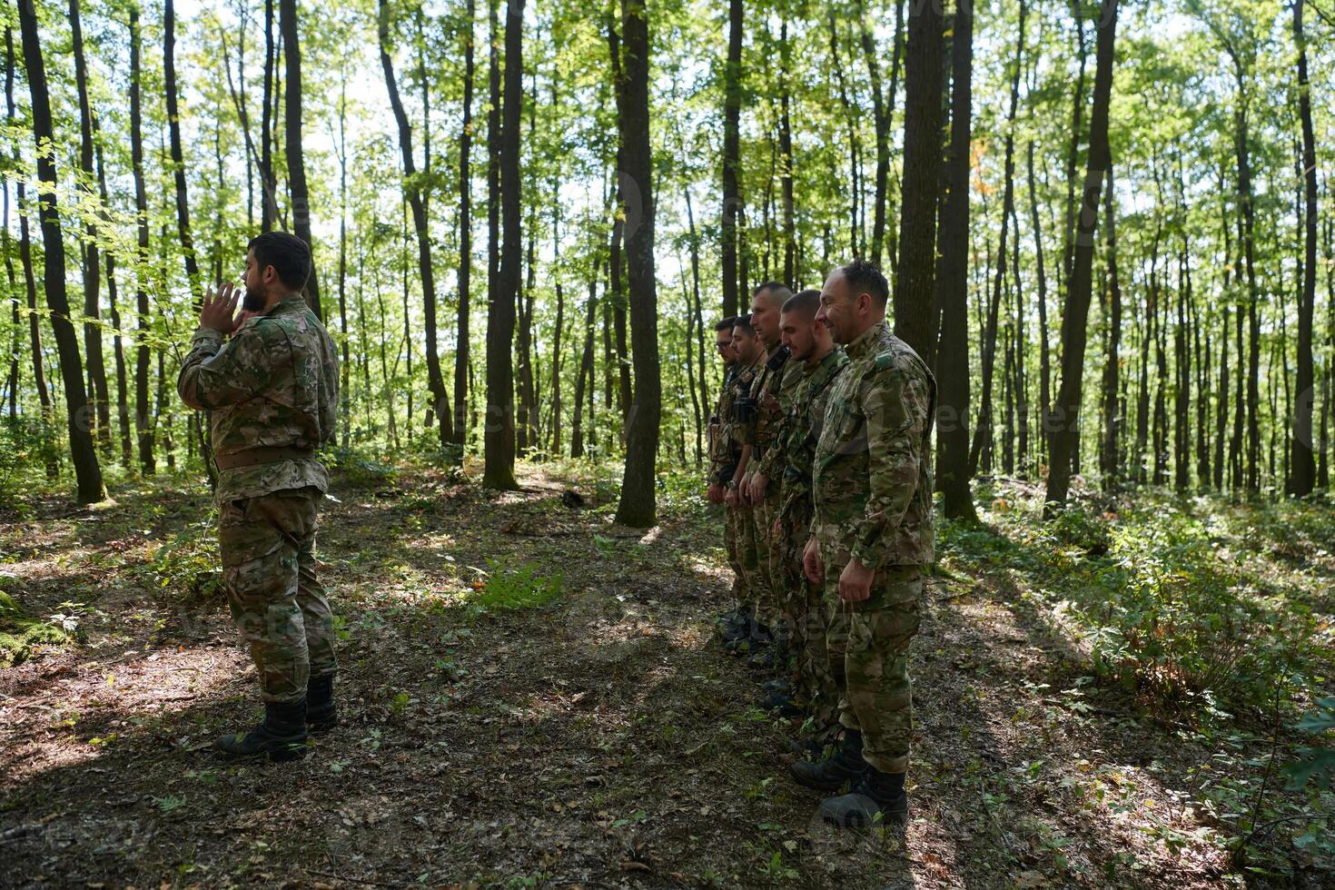 A dedicated group of soldiers engages in Islamic prayer amidst the challenging and perilous conditions of a military operation in dense forested areas photo