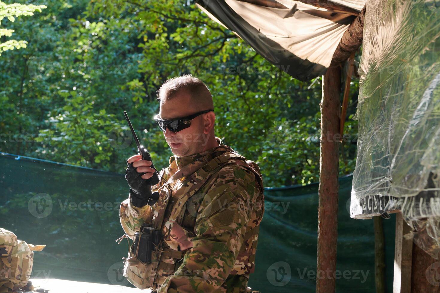 A military major employs a Motorola radio for seamless communication with his fellow soldiers during a tactical operation, showcasing professionalism and strategic coordination photo