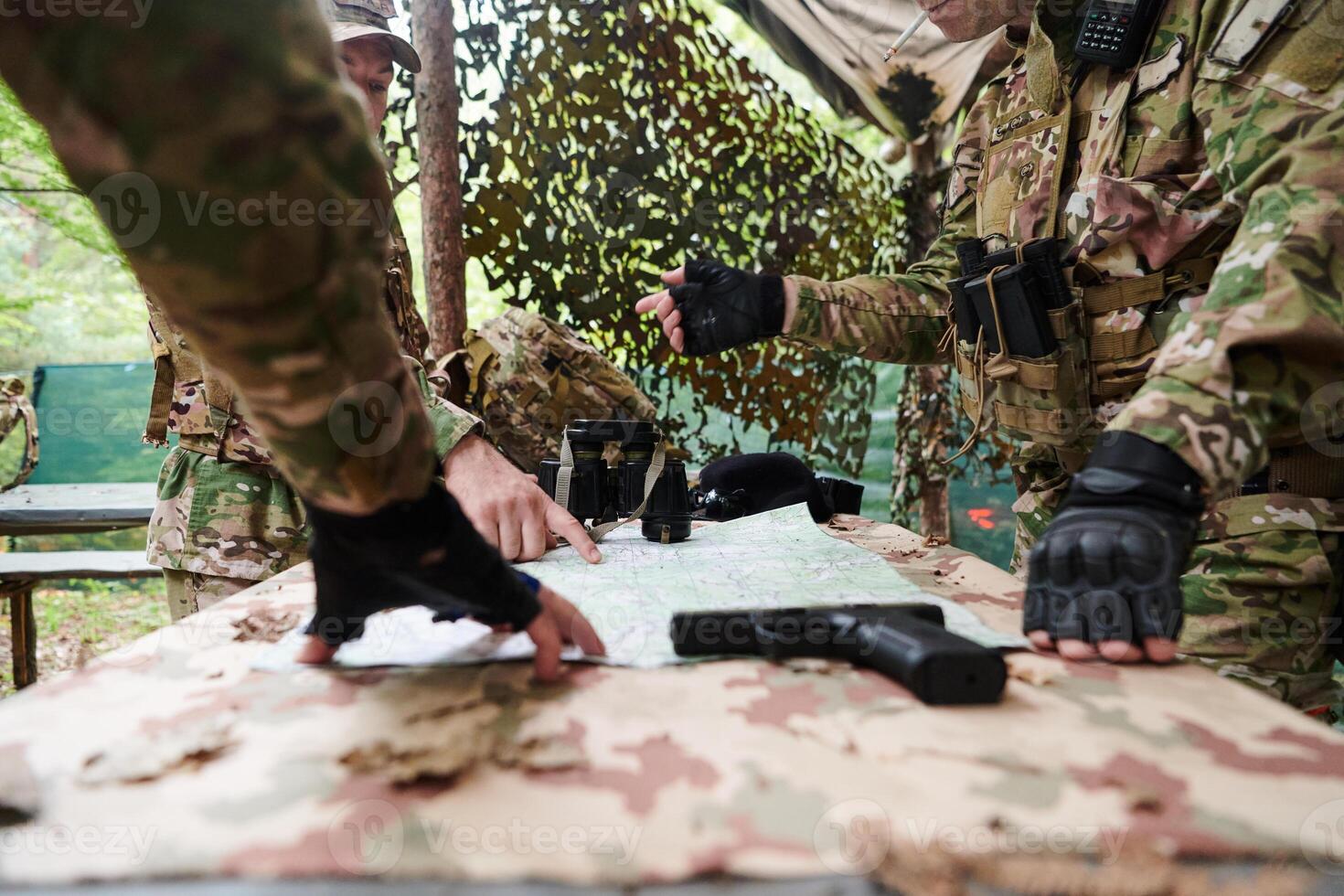 A highly trained military unit strategizes and organizes a tactical mission while studying a military map during a briefing session photo