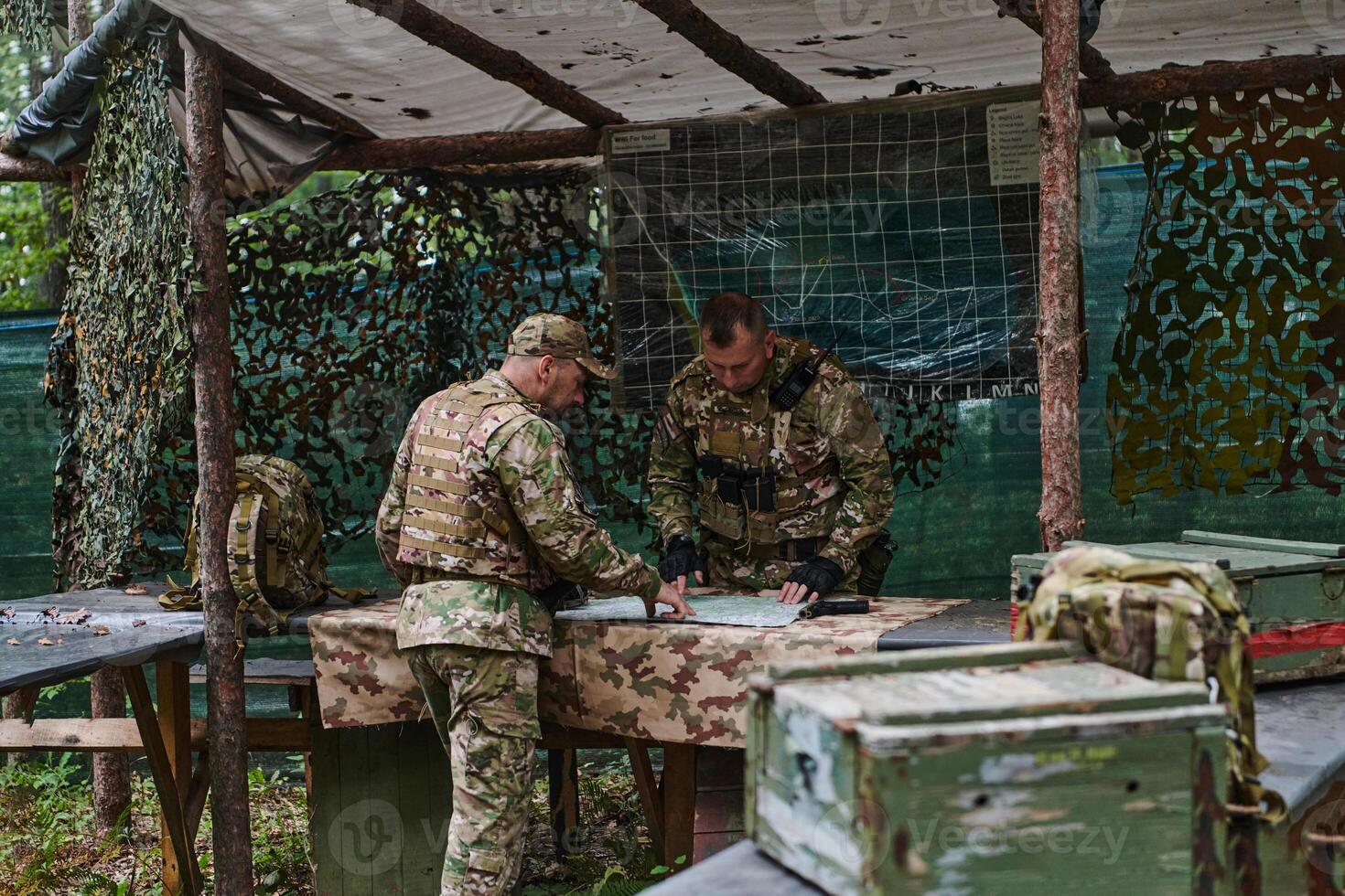 A highly trained military unit strategizes and organizes a tactical mission while studying a military map during a briefing session photo