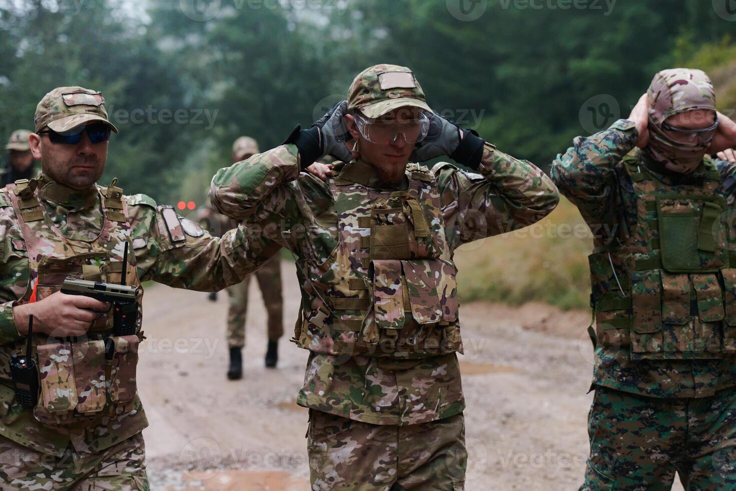A group of elite soldiers leads captives through a military camp, showcasing a tense atmosphere of detention and security operations photo