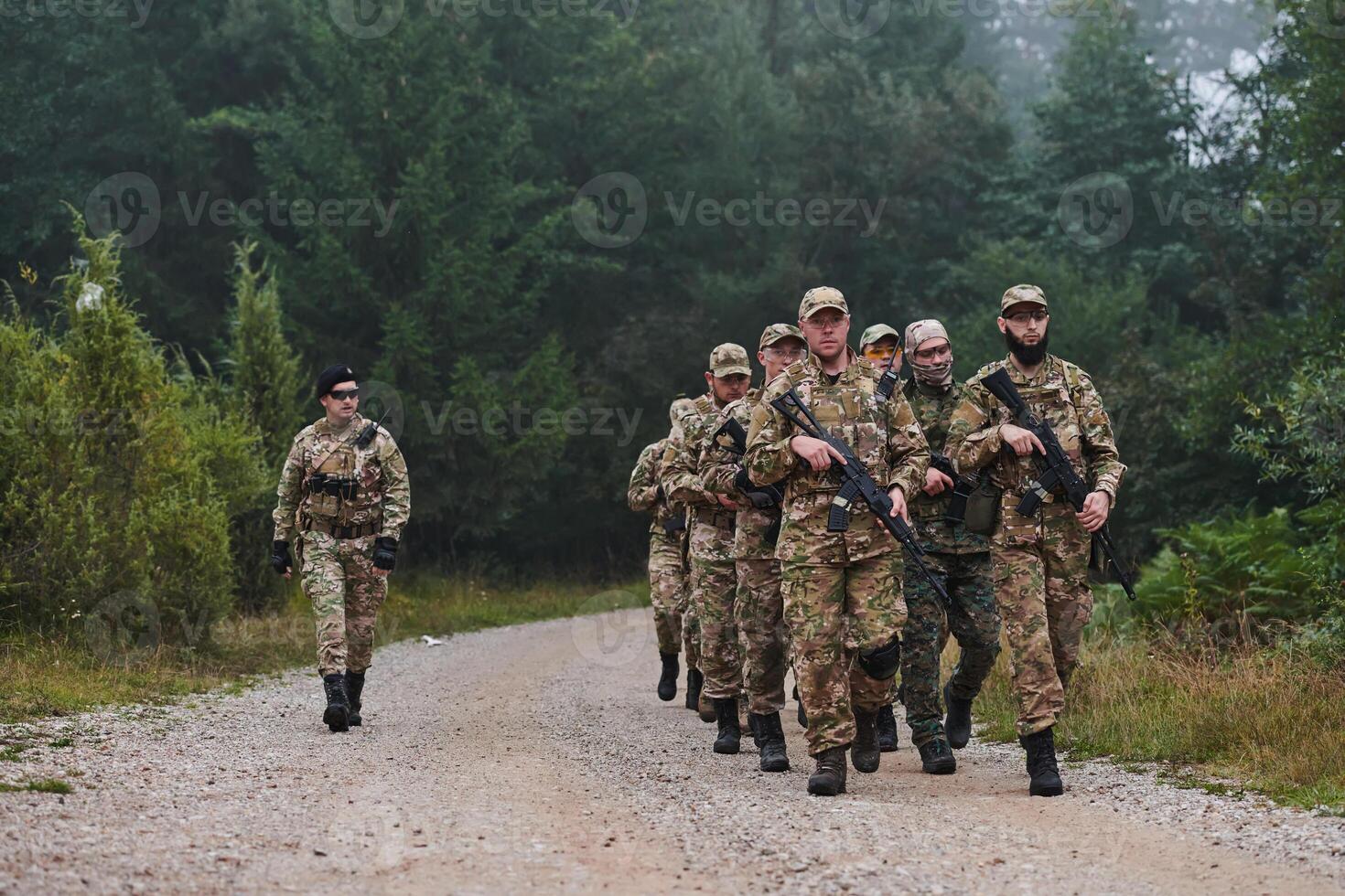 An elite military unit, led by a major, confidently parades through dense forest, showcasing precision, discipline, and readiness for high-risk operations photo