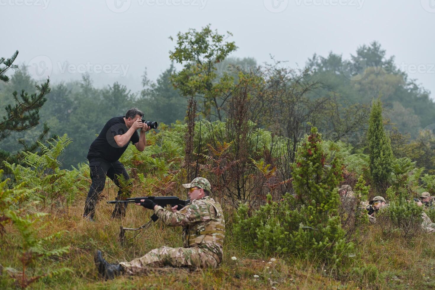 An elite soldier, camouflaged and stealthily navigating through dangerous woodland terrain, executes a covert mission in a secluded forest area photo