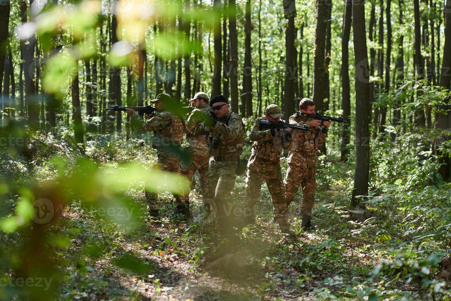A specialized military antiterrorist unit conducts a covert operation in dense, hazardous woodland, demonstrating precision, discipline, and strategic readiness photo