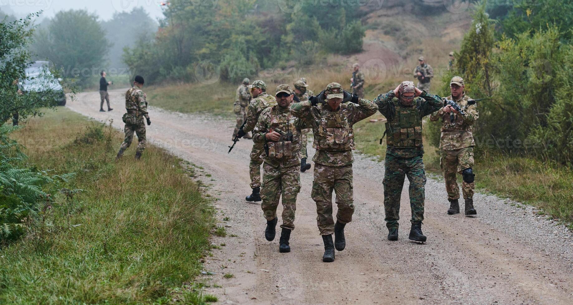 A group of elite soldiers leads captives through a military camp, showcasing a tense atmosphere of detention and security operations photo