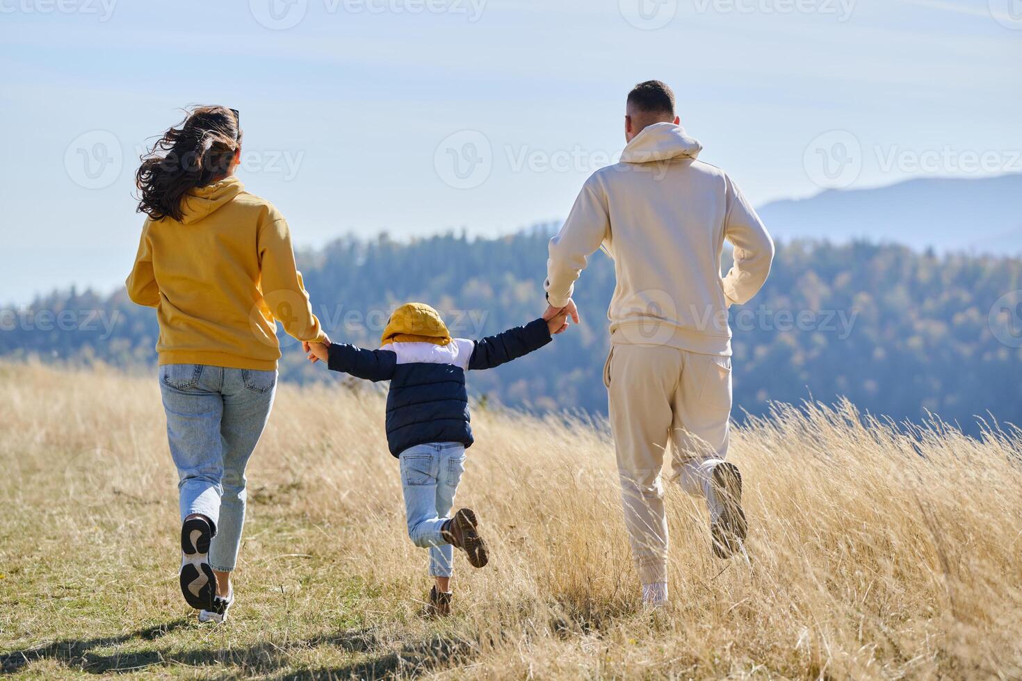 A modern family, along with their son, revels in the joy of a muddy day in nature, running and playing together, encapsulating the beauty of a healthy and active lifestyle photo