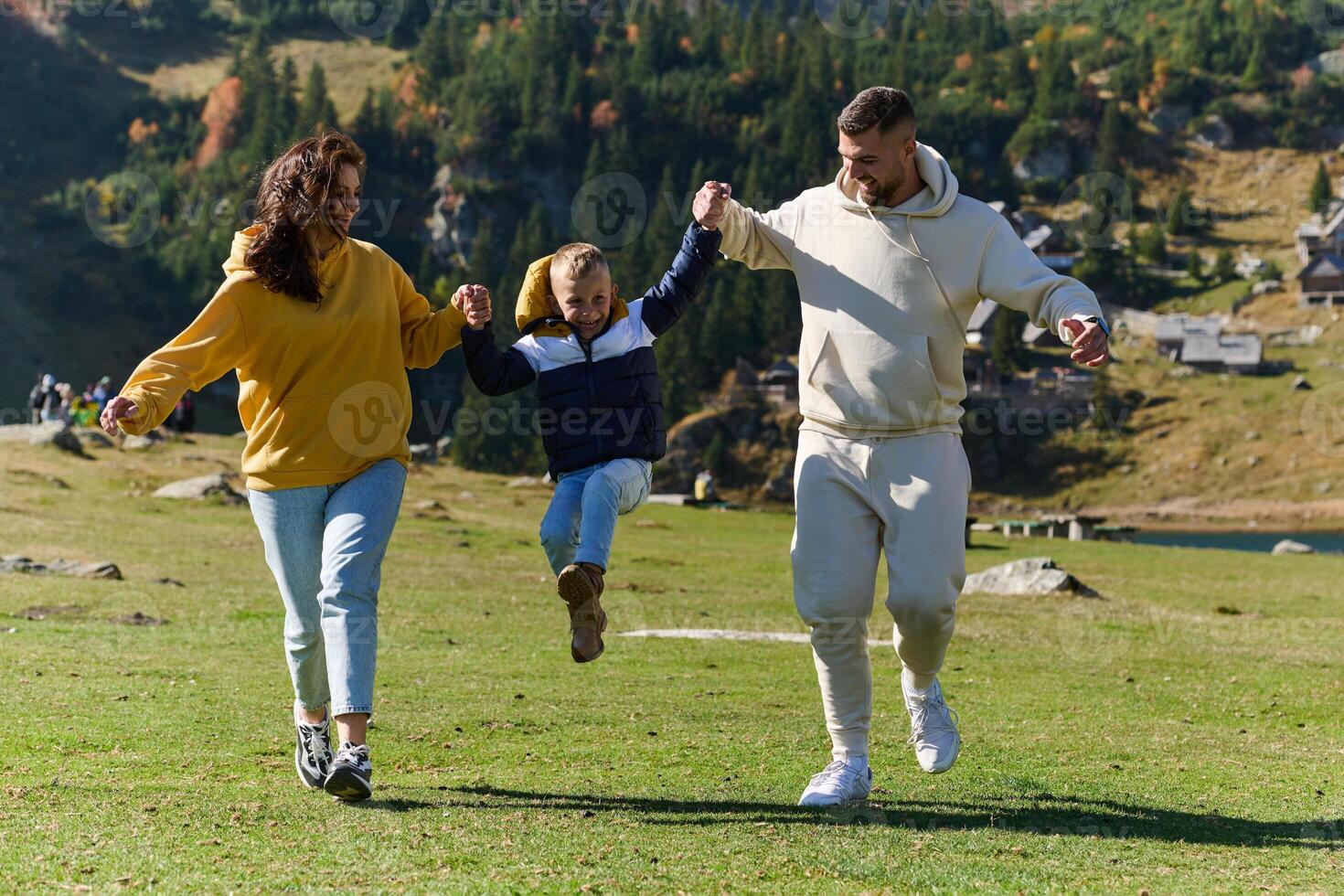 A modern family, along with their son, revels in the joy of a muddy day in nature, running and playing together, encapsulating the beauty of a healthy and active lifestyle photo