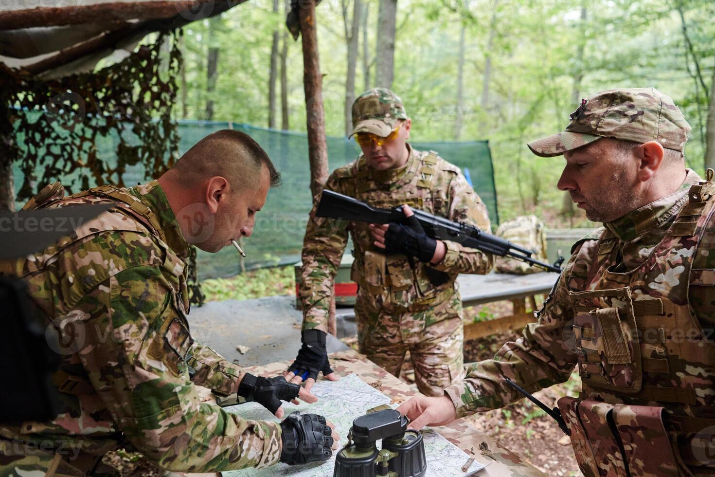 A highly trained military unit strategizes and organizes a tactical mission while studying a military map during a briefing session photo
