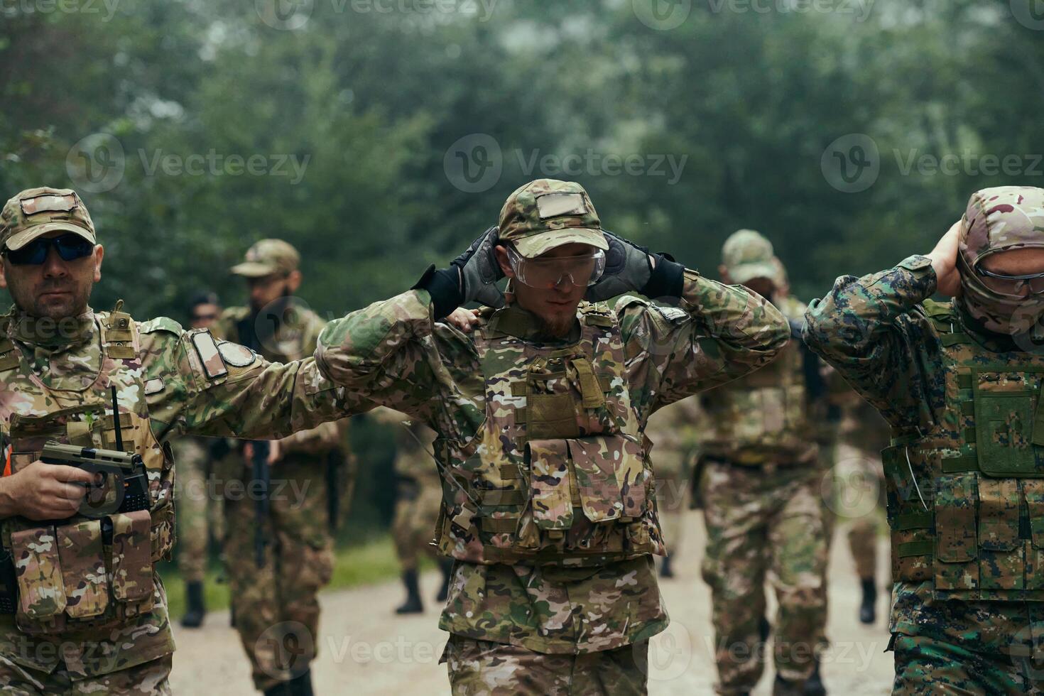 A group of elite soldiers leads captives through a military camp, showcasing a tense atmosphere of detention and security operations photo