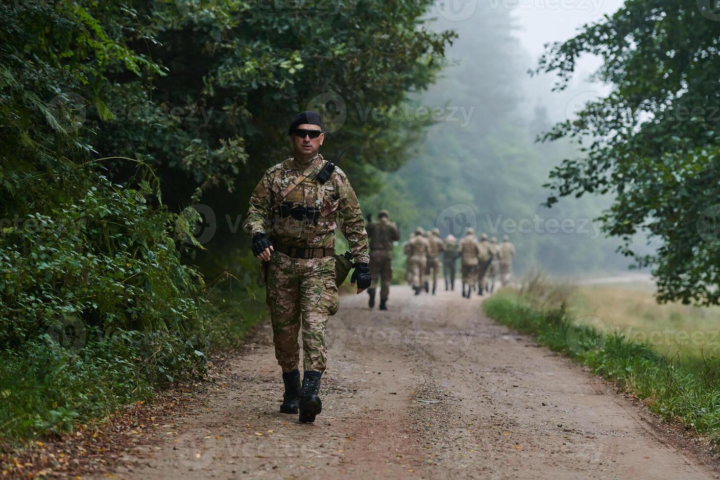 A group of elite soldiers leads captives through a military camp, showcasing a tense atmosphere of detention and security operations photo