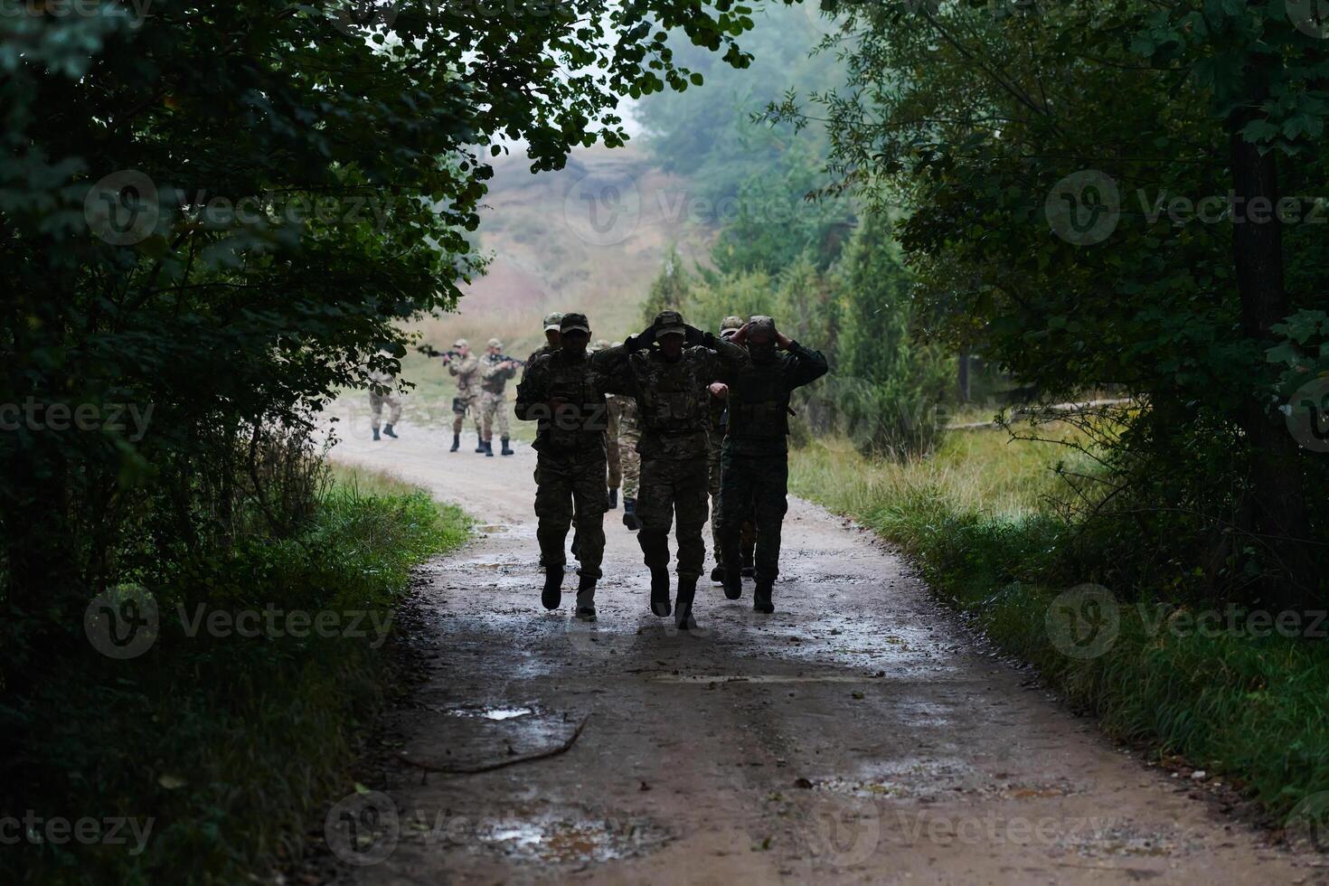 A group of elite soldiers leads captives through a military camp, showcasing a tense atmosphere of detention and security operations photo