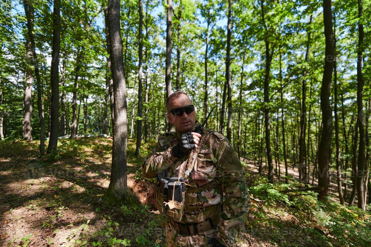 A military major employs a Motorola radio for seamless communication with his fellow soldiers during a tactical operation, showcasing professionalism and strategic coordination photo