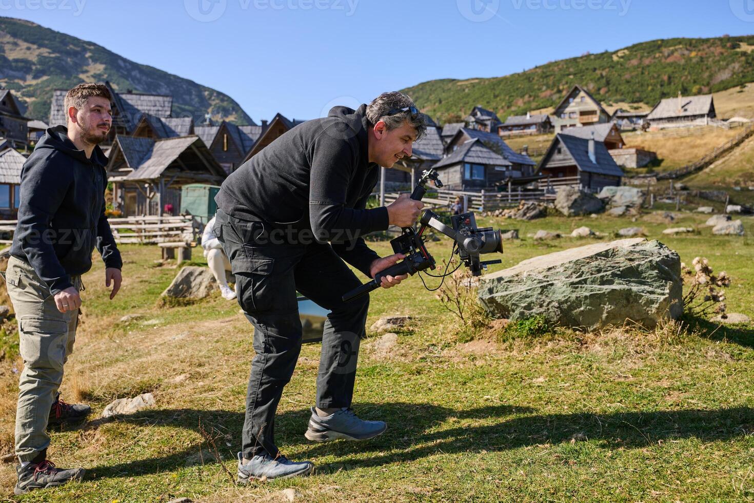A skilled videographer, equipped with professional gear, captures the essence of nature's beauty, expertly documenting the scenic landscape in a cinematic masterpiece that reflects the seamless blend photo