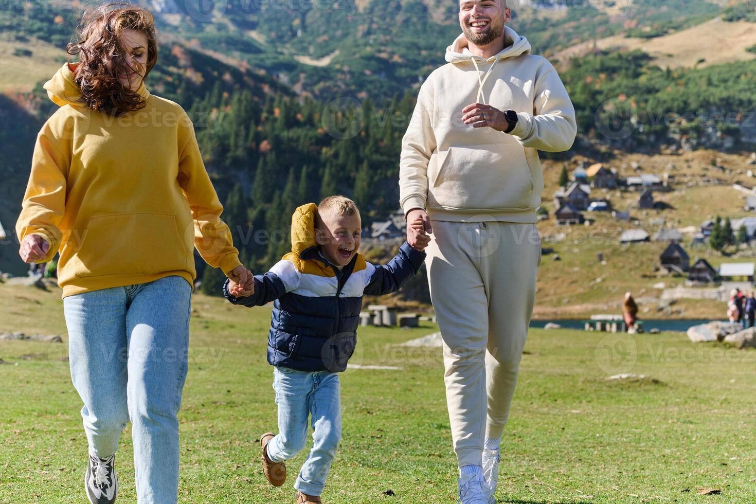 A modern family, along with their son, revels in the joy of a muddy day in nature, running and playing together, encapsulating the beauty of a healthy and active lifestyle photo