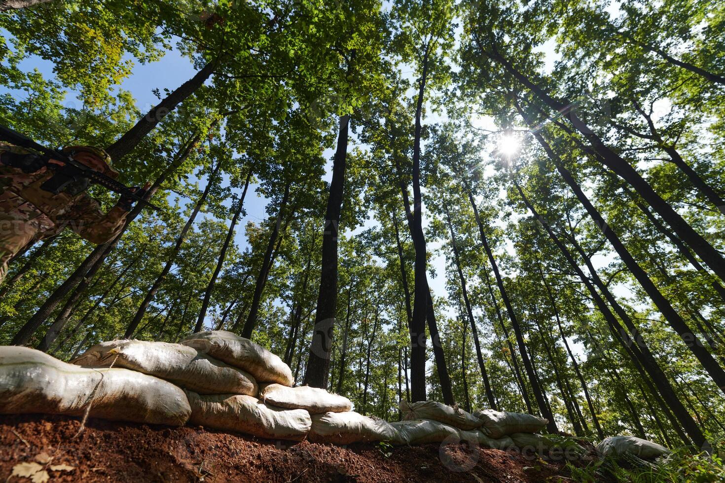 An elite soldier adeptly clears military barriers in the perilous wooded terrain, showcasing tactical skill and agility during specialized training photo
