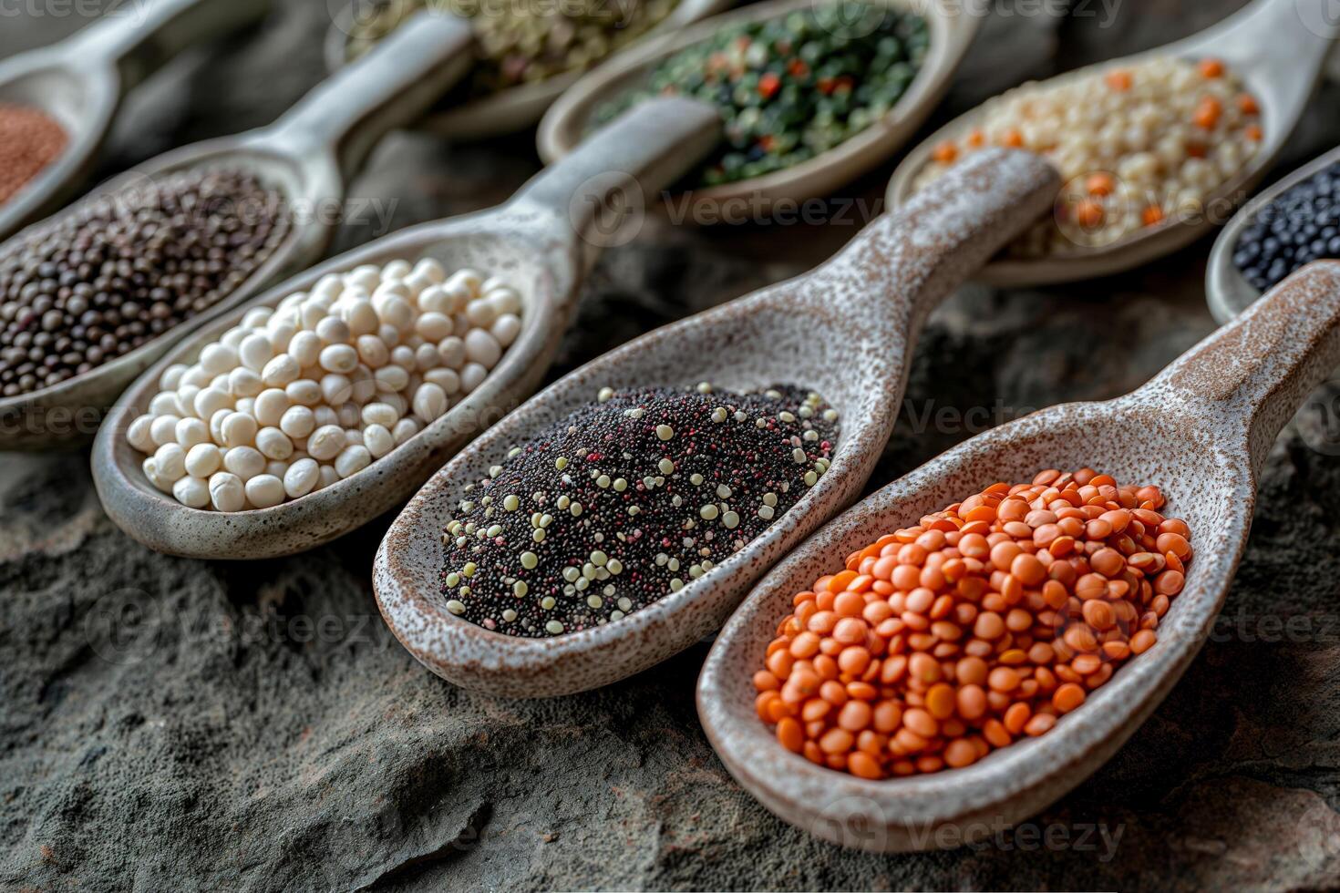CloseUp of Various Colorful Legumes in Rustic Clay Spoons on Stone Surface photo