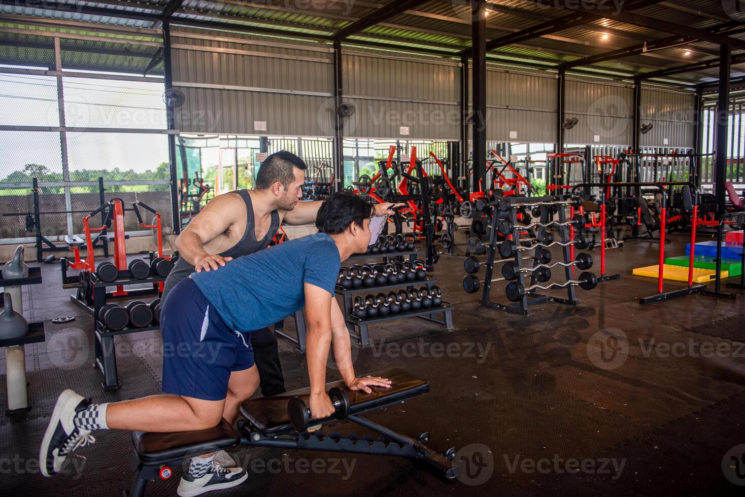 male trainer is planning an exercise program for a client who wants to improve their physical shape in a fitness center photo