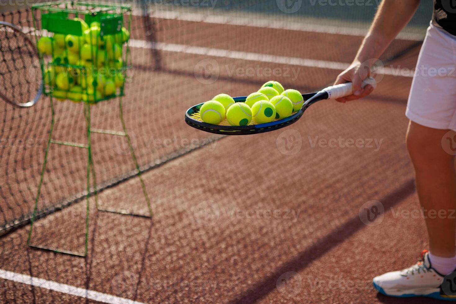 tennis player collecting balls on tennis court close up after training, tennis training photo
