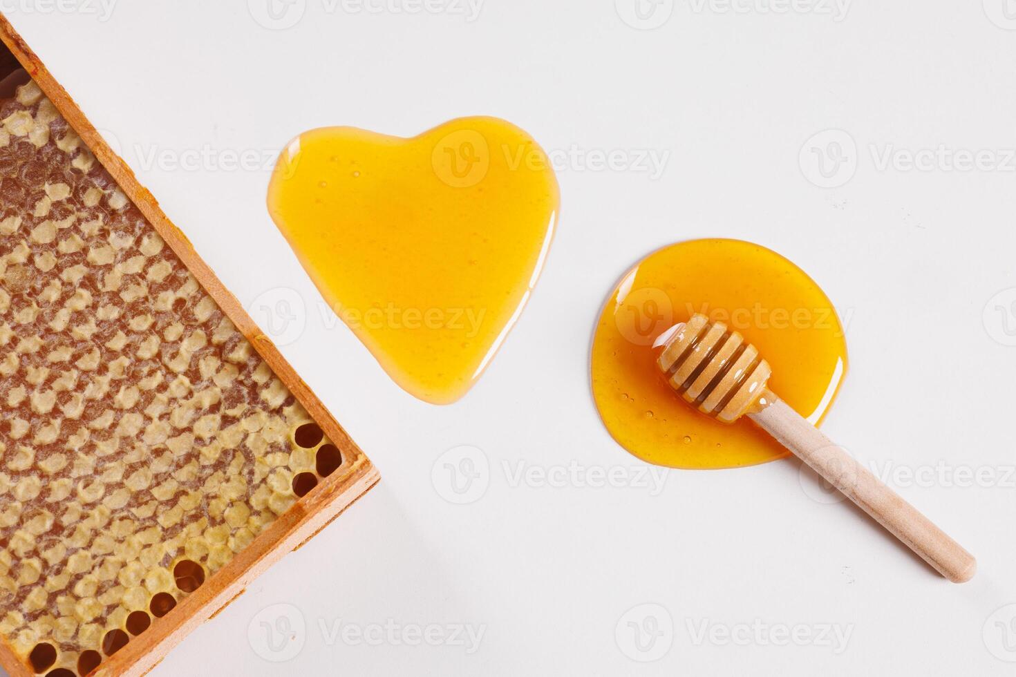 honey in the shape of a heart and bee honeycomb on a white background top view photo