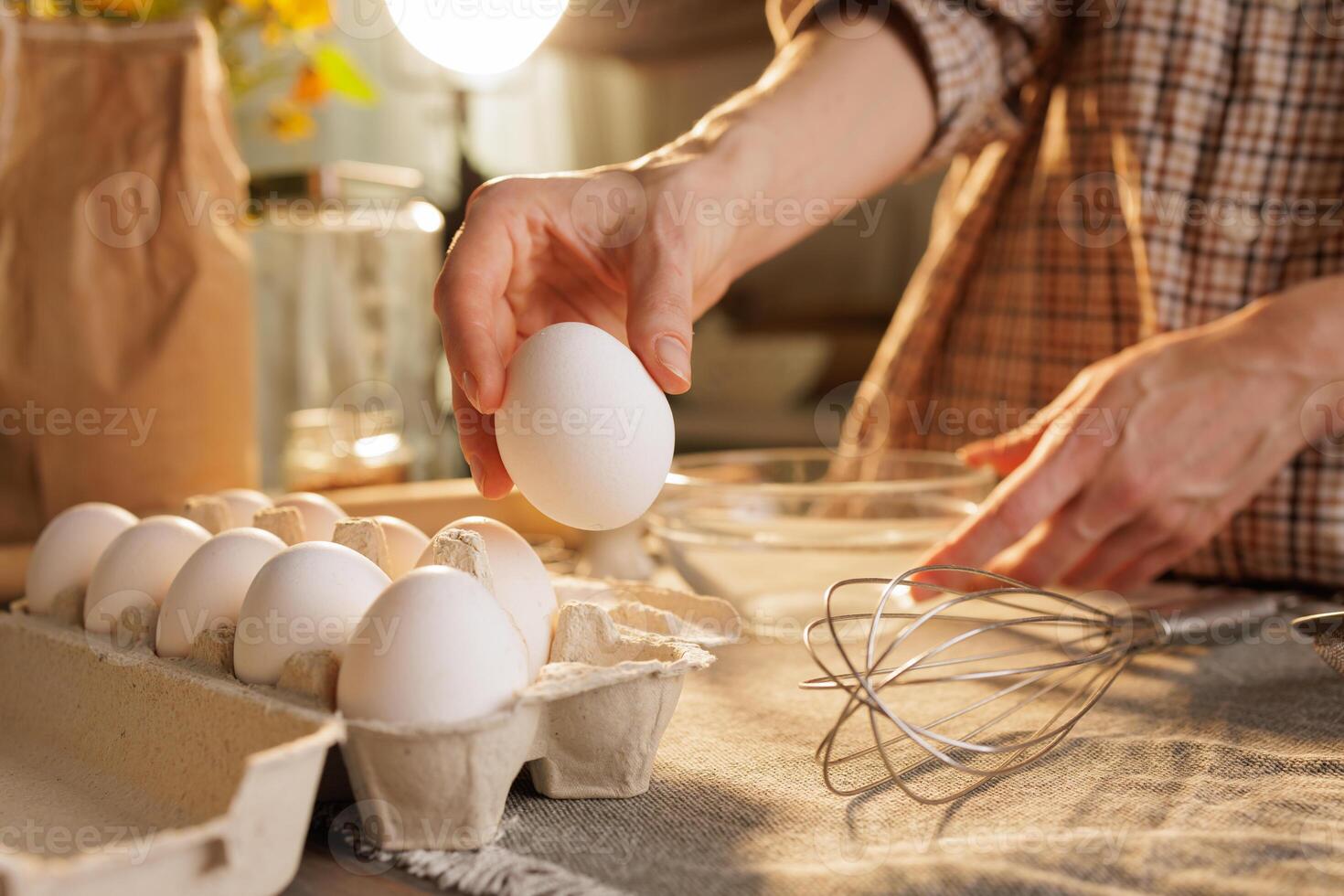 Hand taking out egg from egg carton in kitchen photo