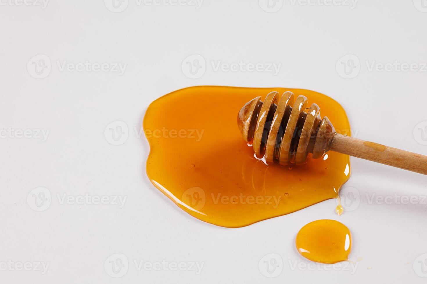 honey spoon with spilled honey on white background, top view photo