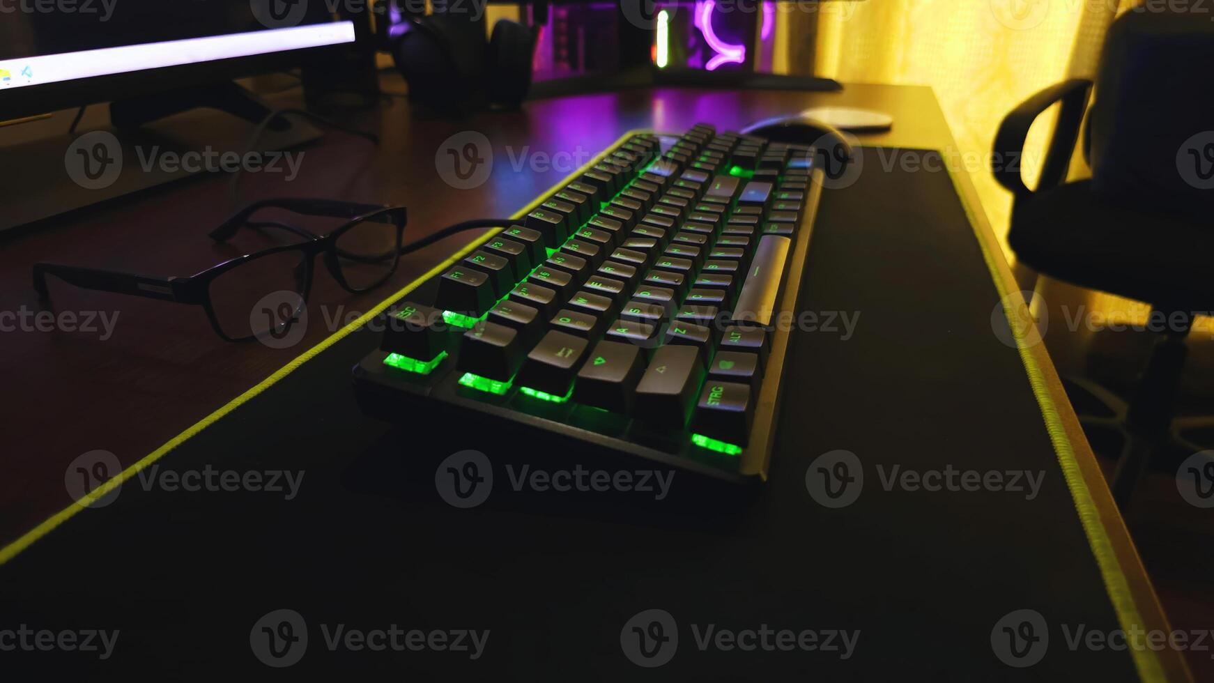 A keyboard and mouse on a desk with a computer monitor photo