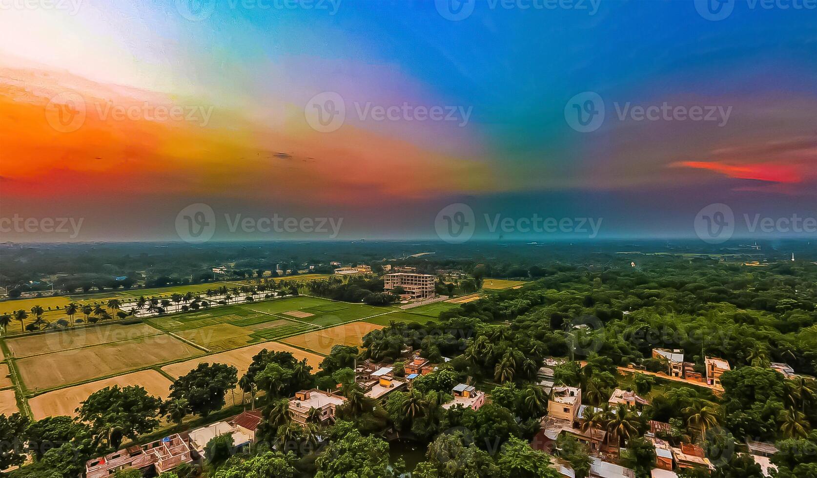 A rainbow over a field with trees and houses photo