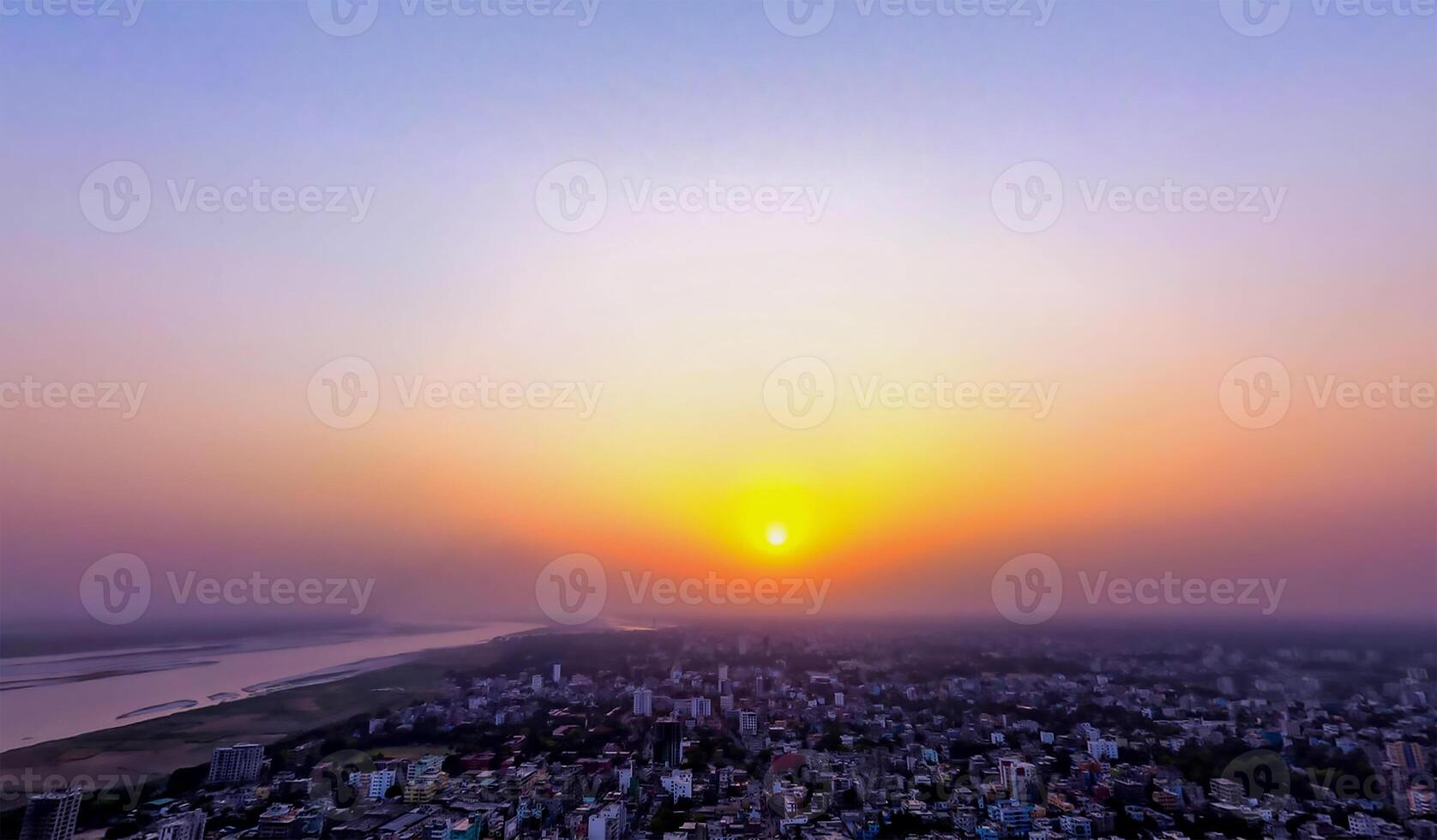 The sun setting over a city with a large body of water photo