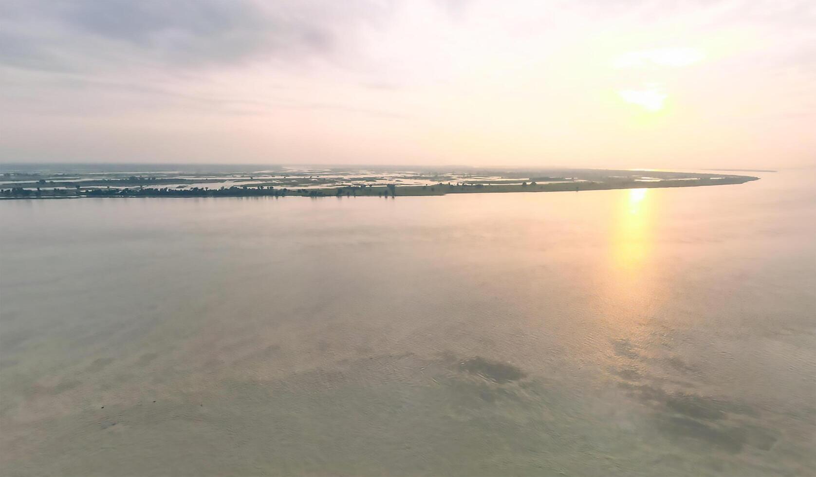 Aerial view of the sun setting over the water photo