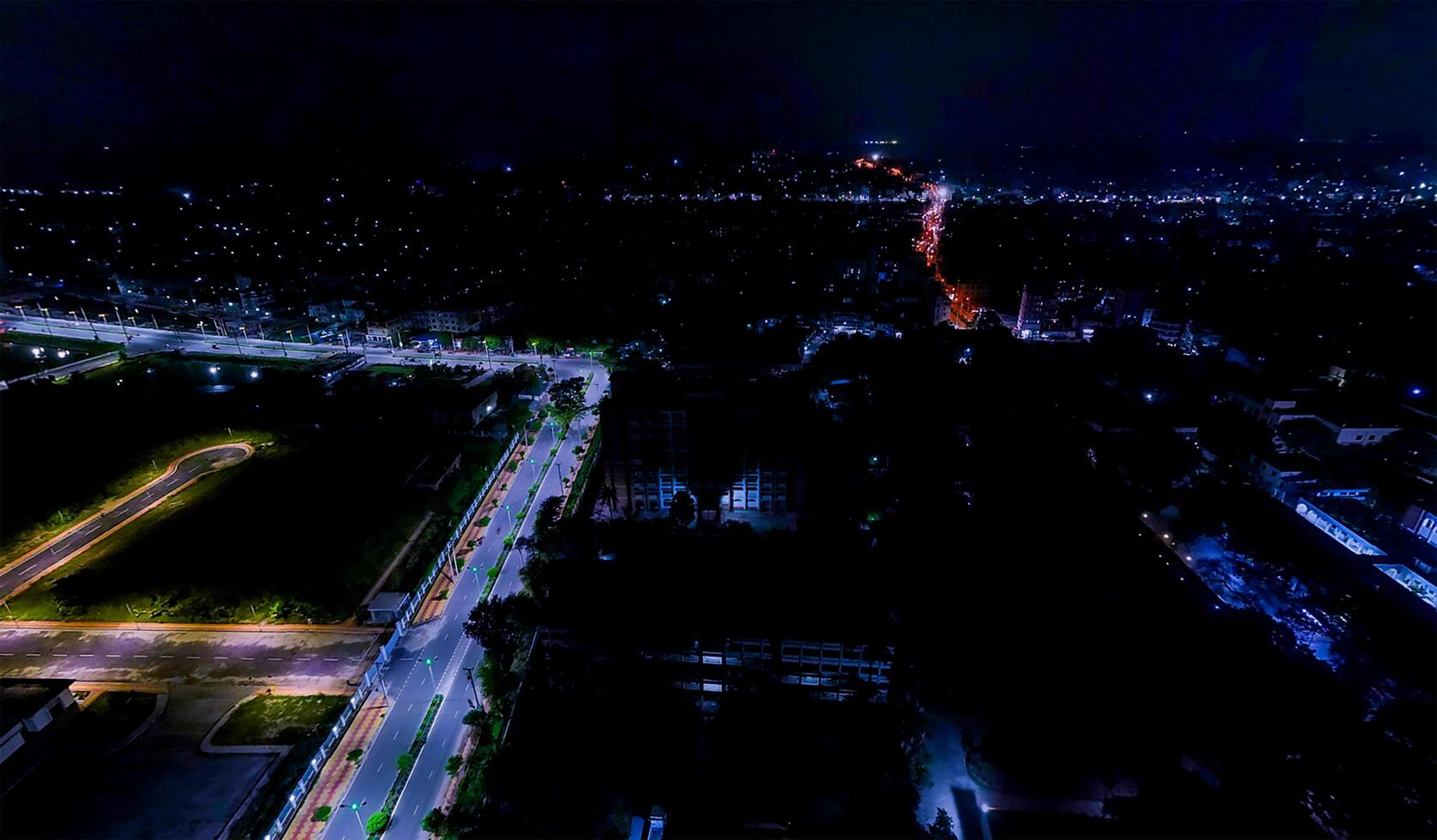 An aerial view of a city at night and the colorful lighting on the road. photo
