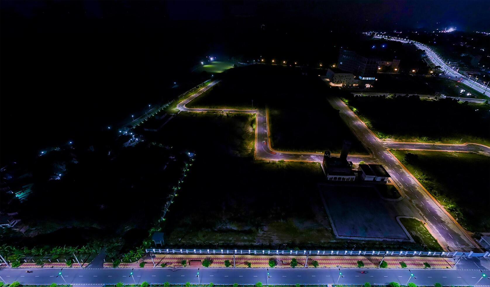 An aerial view of a city at night and the colorful lighting two side on the road. photo