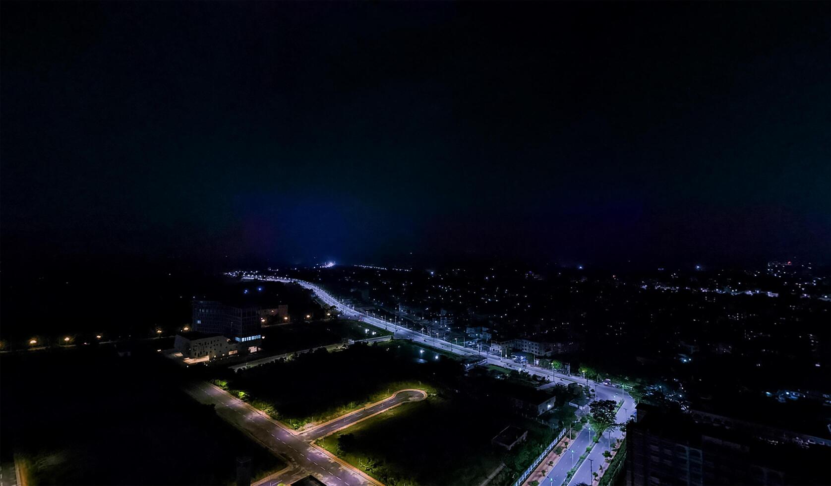 A night time view of a city street and highway with colorfull lighting. photo