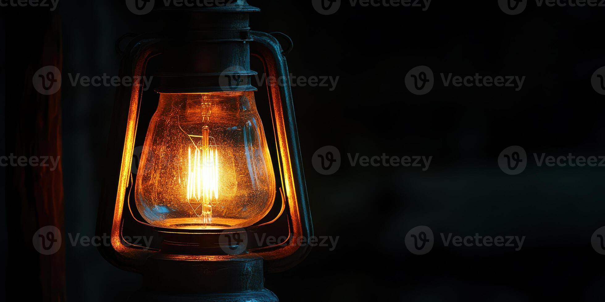 An old fashioned light bulb is lit up in the dark photo