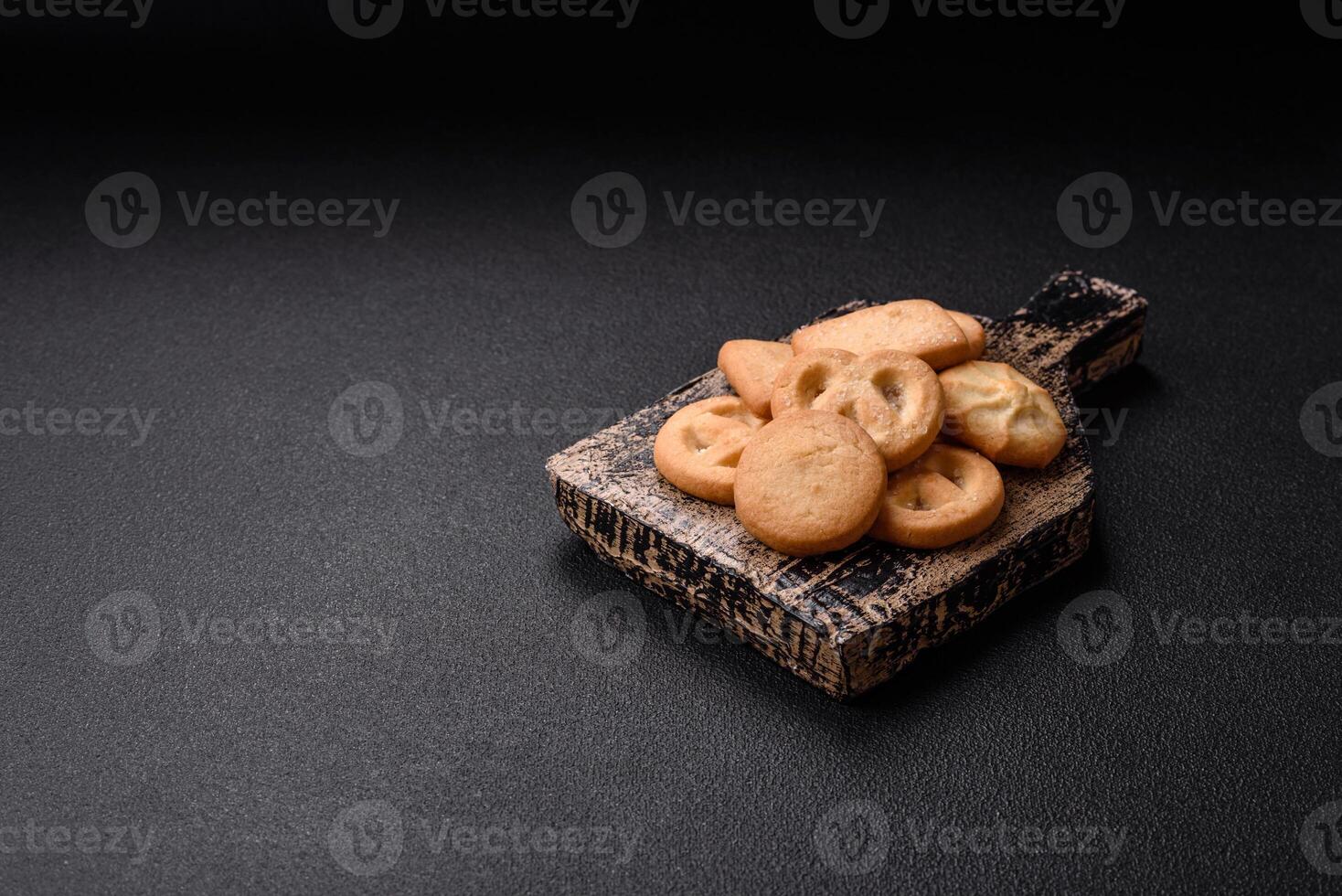 Delicious fresh sweet crispy butter cookies on a dark background photo