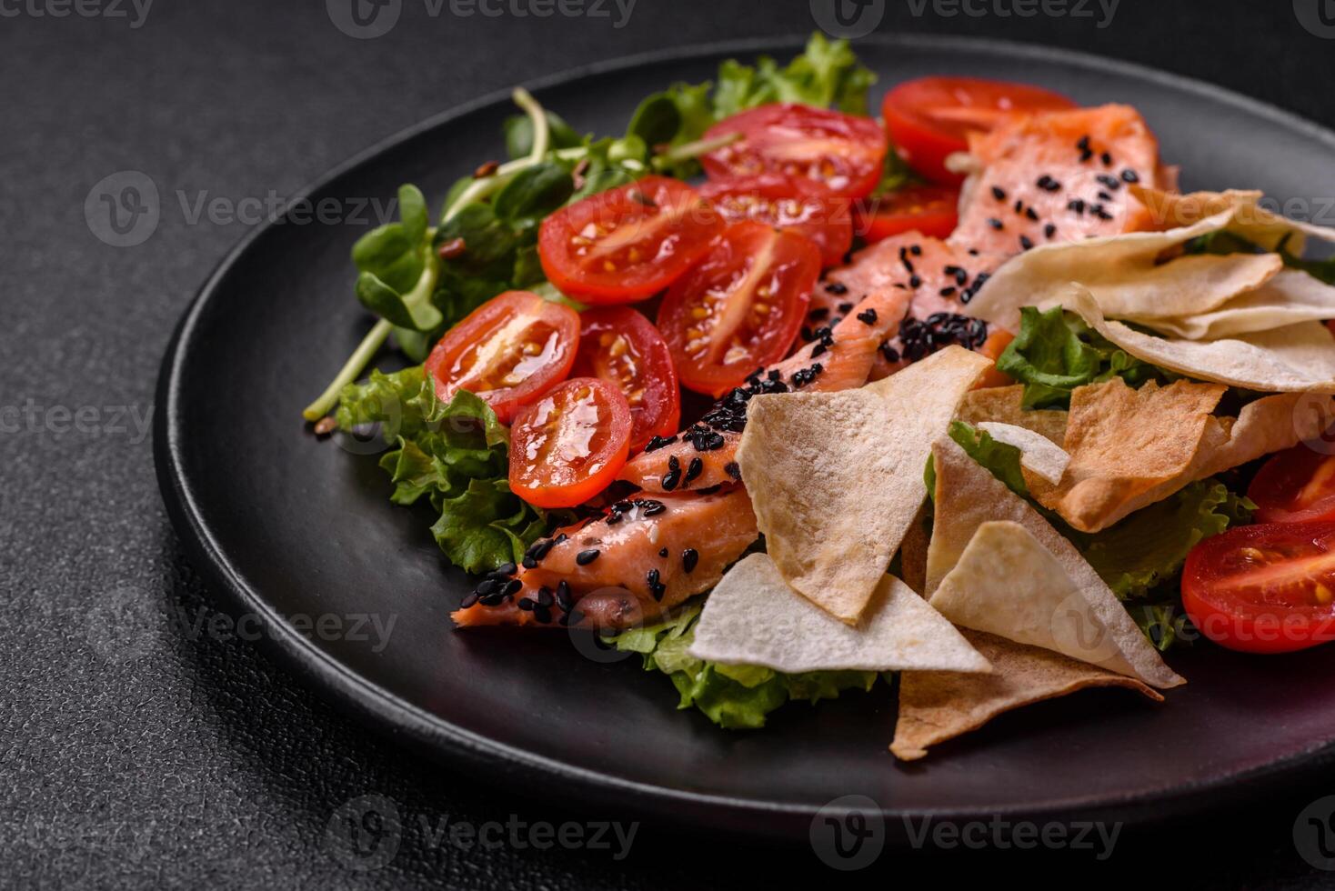 Delicious fresh caesar salad with salmon, lettuce, tomatoes and egg photo