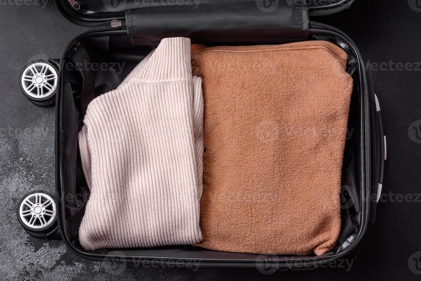 An open suitcase with wheels with clothes inside. Preparing for your trip photo