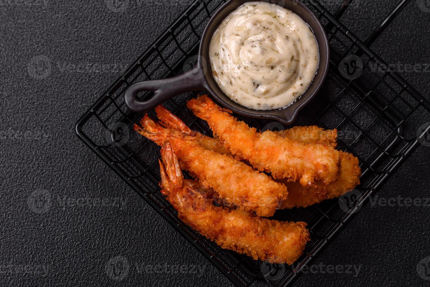 Hot crispy shrimp breaded with salt and spices with white sauce photo