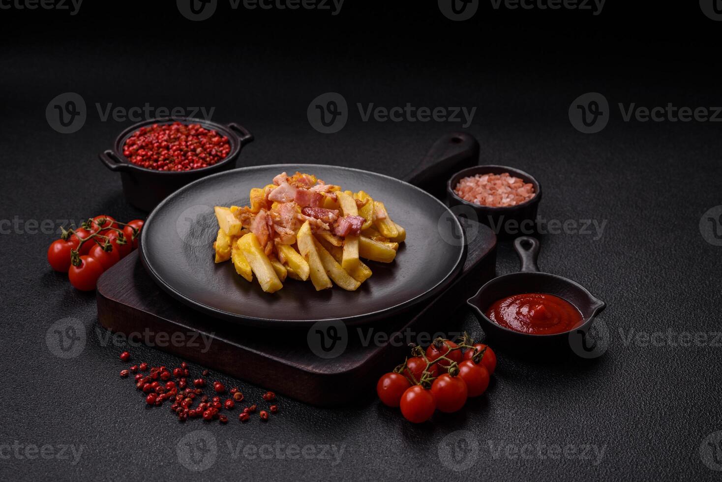 Crispy French fries with pieces of bacon, salt and spices photo